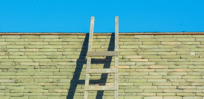 Ladder leaning against a brick wall